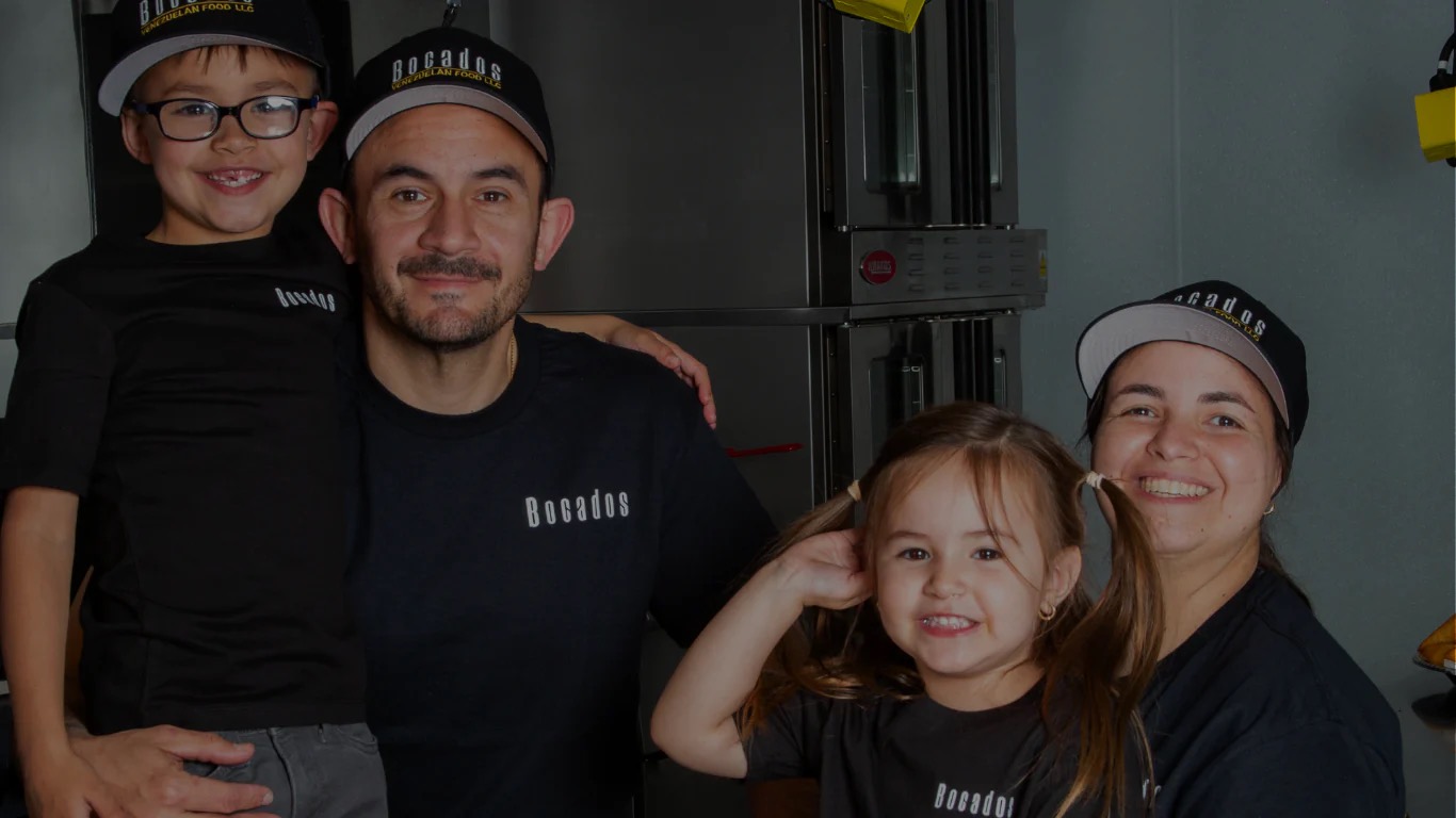 The Bocados family in their kitchen, wearing Bocados caps and shirts.
