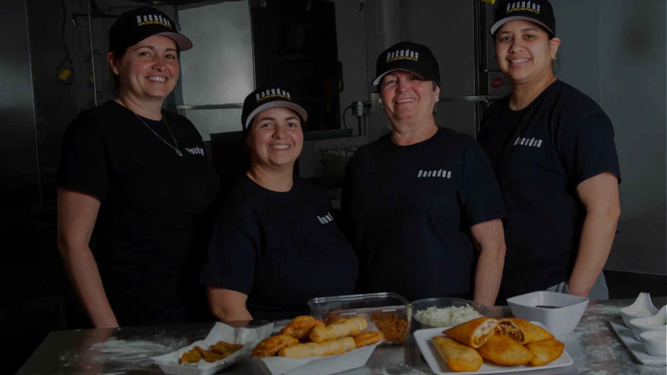 The Bocados team behind a counter of freshly fried empanadas, tequeños and queso.